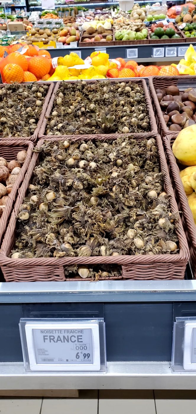 Fresh French hazelnuts piled in baskets at the market